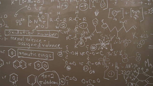 A black board is full of chemistry equations