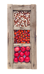 old window frame with apples, beans and rose hips