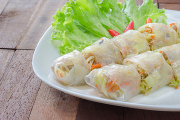 Spring rolls on white plate,wooden background