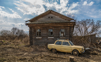 Старый заброшенный деревянный дом с машиной в деревне © starets