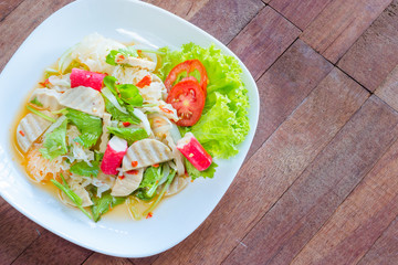 Thai cuisine spicy pork salad on wood background or Yum Moo Yor