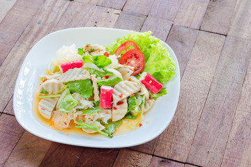 Thai cuisine spicy pork salad on wood background or Yum Moo Yor