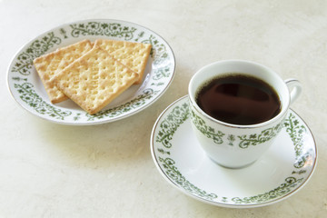 Coffee cup with crackers on marble table