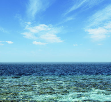 Ocean water above blue sky background