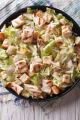 Caesar salad with chicken closeup vertical top view 
