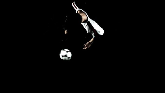 Soccer player dribble ball on a black floor. Wide shot.