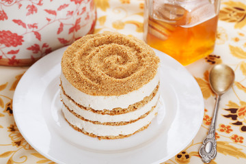 food honey cake with crumb and layers of cream in still life