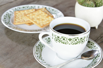 Coffee cup with crackers on wood table