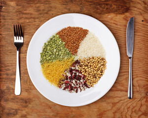 Plate with different cereals and garnish on table.