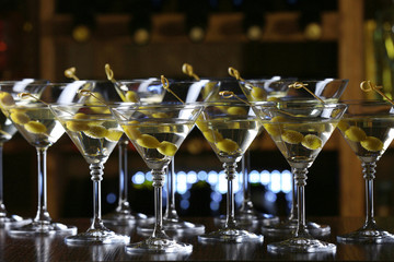 Glasses of cocktails on bar background