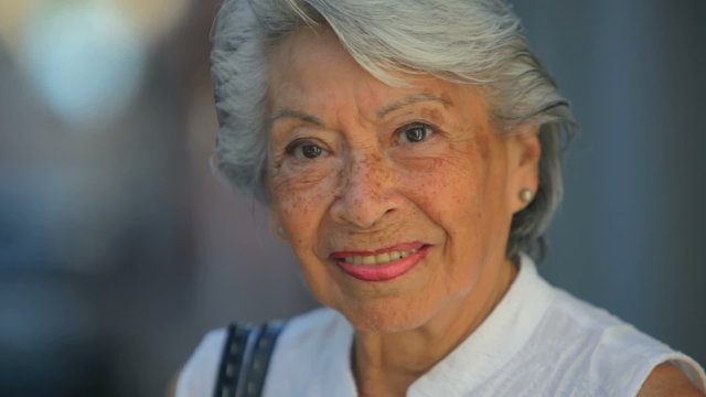 Close up shot of an old Spanish lady looking into the camera and smiling
