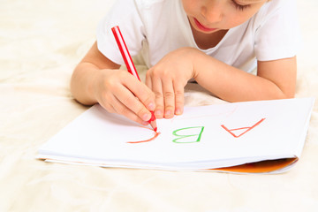 little boy learning to write letters