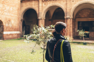Fototapeta na wymiar Stylish woman walking through a cloister