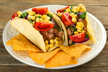 Mexican food Taco in plate on wooden table, closeup
