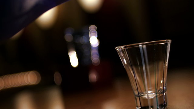 Saki being poured into a shot glass. Close up shot.