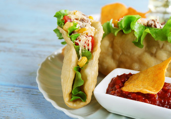 Tasty taco with tomato dip on plate and vegetables 