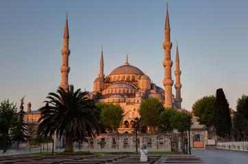 girl sitting on a bench looks at the Blue mosque 