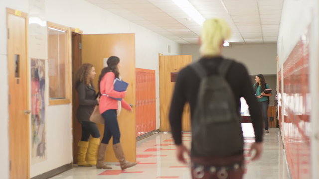 Classroom doors open and an empty hallway fills with high school students