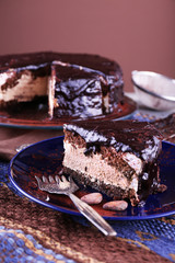 Delicious chocolate cake with icing in plate on table, closeup