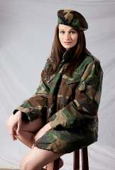 Woman in military jacket, looking thoughtful