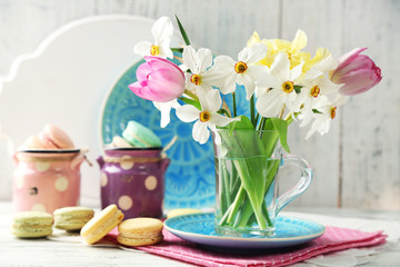Spring bouquet in glass mug  and macaroons 