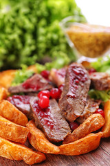 Beef with cranberry sauce, roasted potato slices 