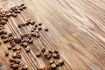 Naklejka premium Coffee beans on wooden background