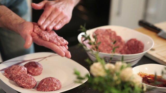 Chef making burgers in kitchen with ground beef