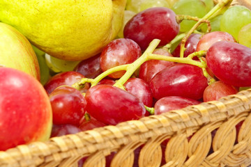 Fresh fruits on a straw pot.