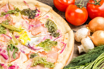 Close up image of pizza with vegetables around