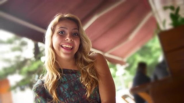 Young woman smiles at a cafe 