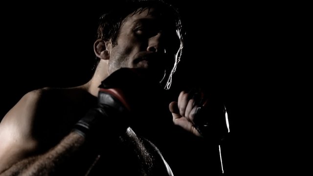 Fighter puts in his mouth piece and clenches his fists, showing he is ready