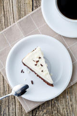 Vanilla cheesecake slice on wooden background.