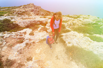 mother with little daughter travel in mountains