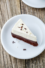 Vanilla cheesecake slice on wooden background.
