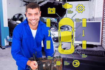 Composite image of smiling male machanic repairing car engine