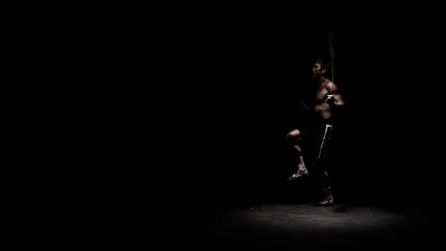 Athlete does fitness training by jump roping. Medium shot.