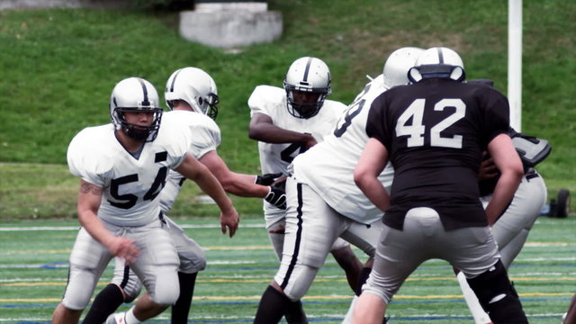 A Running Back Receives A Handoff And Breaks Tackles For A Long Run.