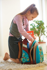 Kind packt zu Hause den Schulranzen