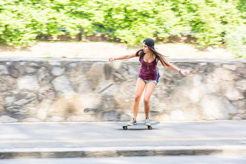 Beautiful mixed race girl skating in the city, panning