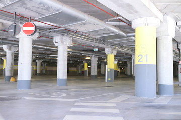 Fototapeta premium Underground park of a mall with columns and ventilation ducts