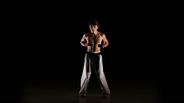 Man training taekwondo or karate jumping, high kick and fist