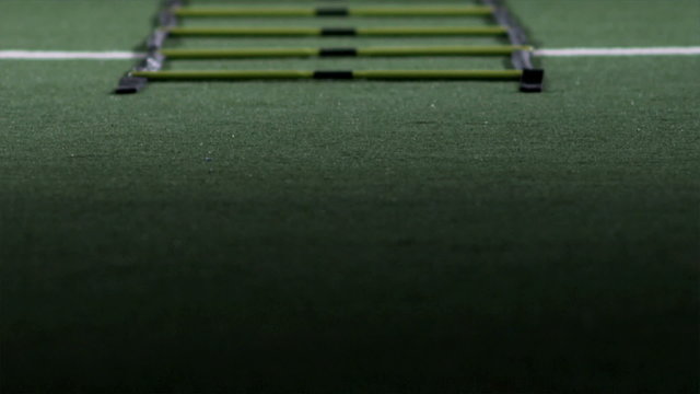 An african american man practicing speed and agility across turf