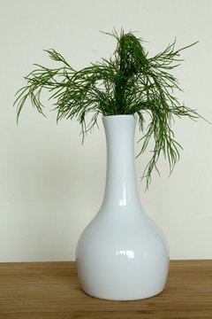 Dill in einer Vase auf Holzbrett