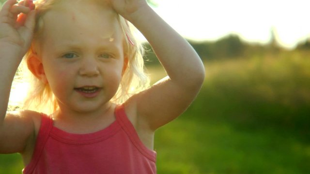 A cute little girl puts on a pair of diva sunglasses and plays with her hair