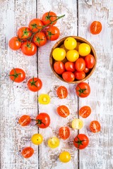 yellow and red cherry tomatoes on old white wooden table