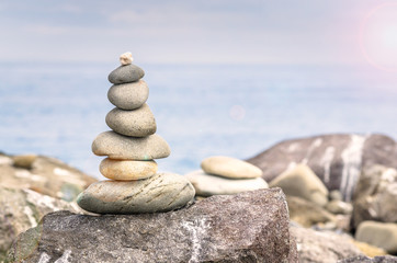 Fototapeta na wymiar Pile of Stones on a Beach at Sunset. Concept of Balance