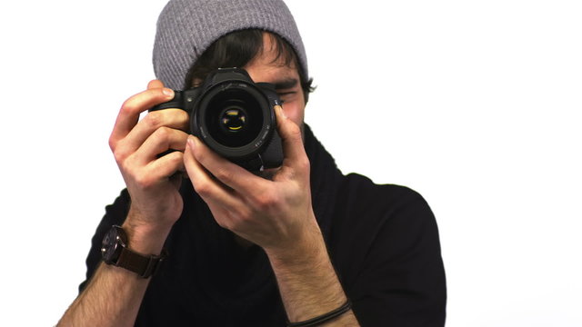 A cute make photographer looks at the camera while taking pictures