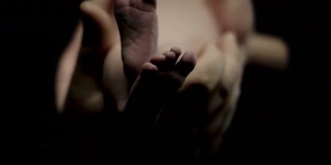 Close up of a baby's feet being held by his father