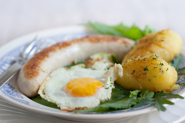 Bratwurst und Spiegelei auf Spinat und Karoffel
